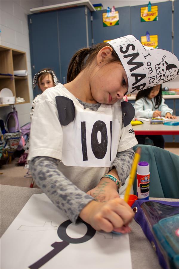 girl dressed as dalmatian dog in classroom